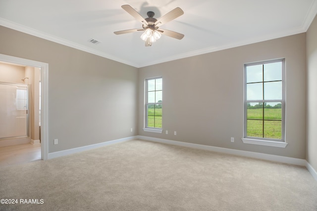 spare room featuring visible vents, ceiling fan, baseboards, light colored carpet, and ornamental molding