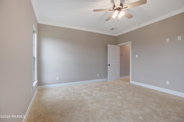 unfurnished room featuring visible vents, light colored carpet, crown molding, and baseboards