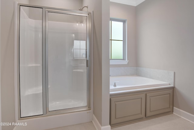 full bath with a shower stall, a garden tub, and baseboards