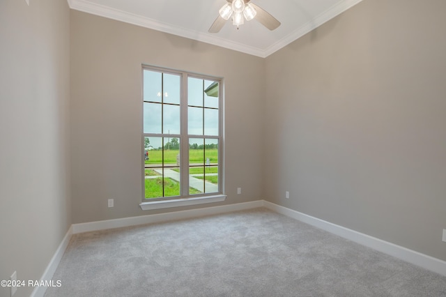 carpeted spare room featuring a ceiling fan, baseboards, and ornamental molding