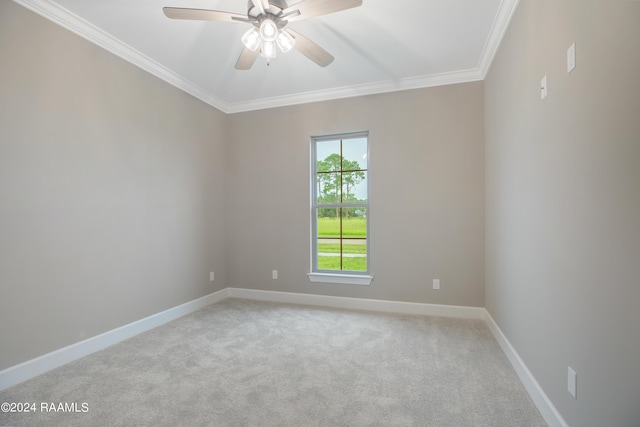 empty room featuring crown molding, carpet flooring, baseboards, and ceiling fan