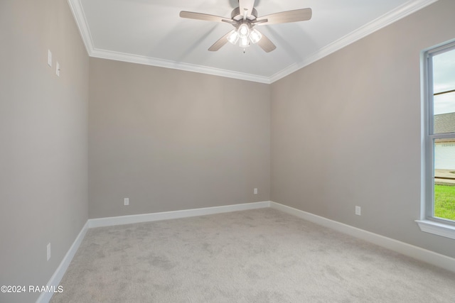 empty room with light colored carpet, a ceiling fan, baseboards, and ornamental molding