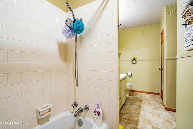 full bathroom featuring tile patterned flooring, toilet, tiled shower / bath combo, and vanity