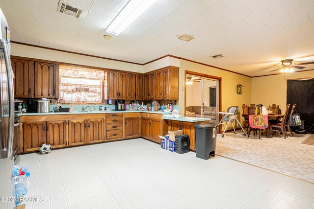 kitchen featuring ornamental molding, sink, light tile patterned floors, kitchen peninsula, and ceiling fan