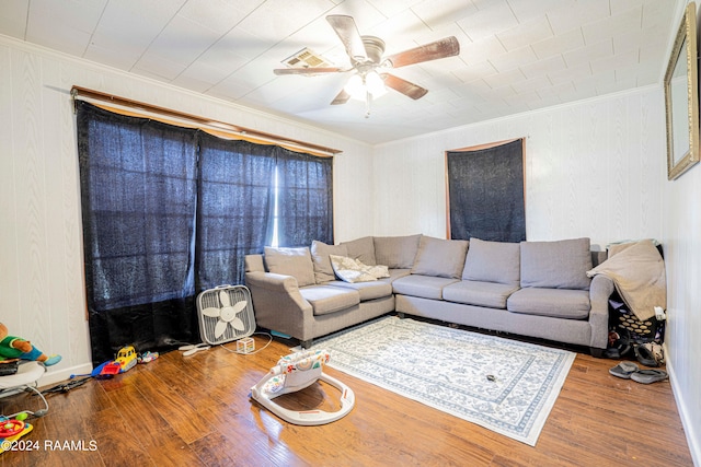 living room with ceiling fan, wood-type flooring, and ornamental molding