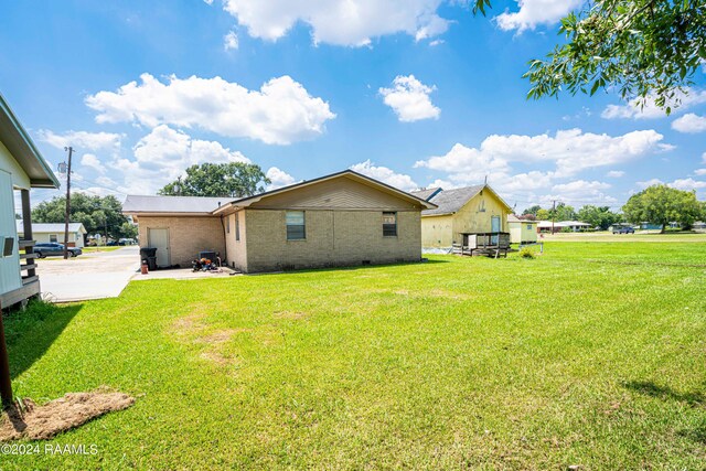 rear view of property featuring a patio area and a yard