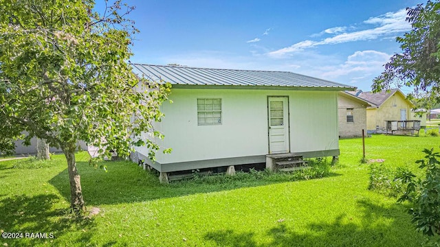 1605 Charity St, Abbeville, LA 70510 - rear view of house with a lawn, metal roof, and entry steps