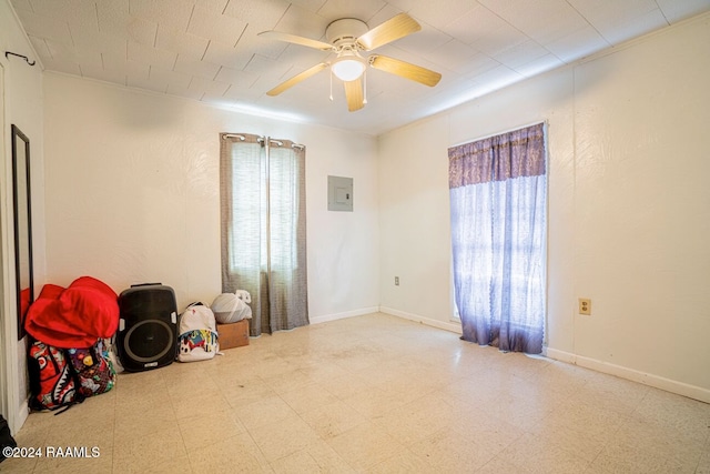 spare room featuring ceiling fan, electric panel, and tile patterned floors