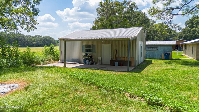 rear view of house featuring a lawn and a patio area