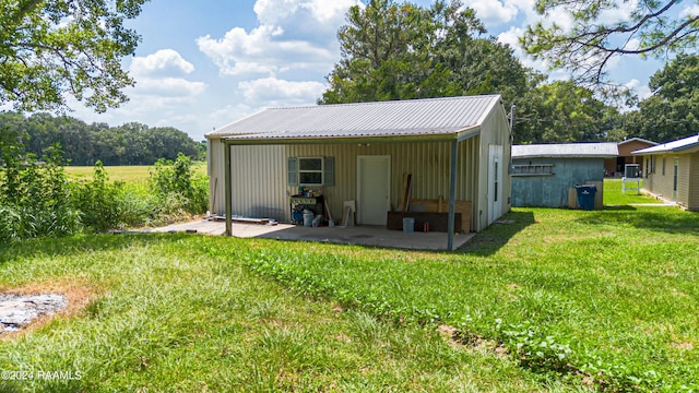 back of house featuring an outdoor structure and a yard