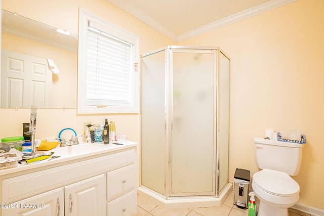 bathroom with crown molding, toilet, a shower with shower door, tile patterned flooring, and vanity