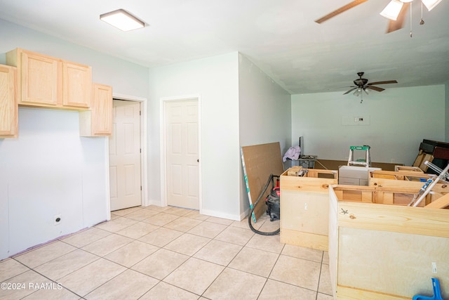 interior space featuring light tile patterned floors, ceiling fan, and light brown cabinetry