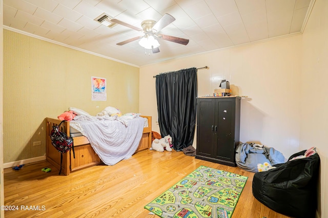 bedroom with crown molding, ceiling fan, and light hardwood / wood-style flooring