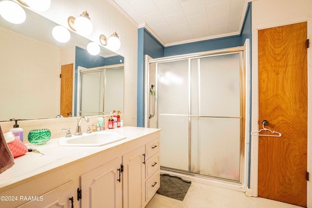 bathroom featuring ornamental molding, a shower with door, and vanity