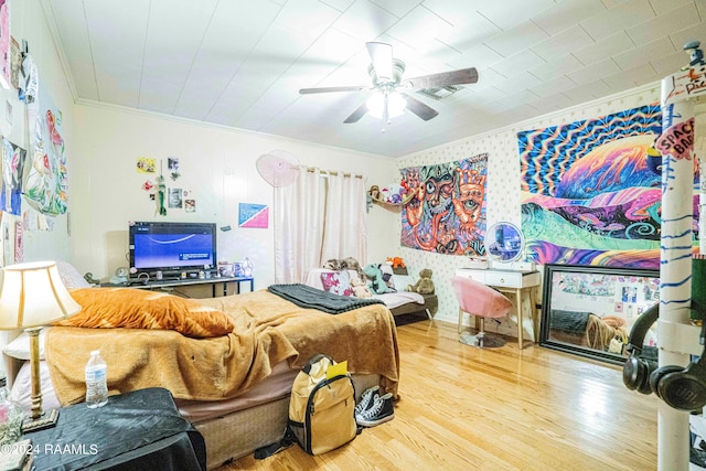 bedroom with hardwood / wood-style flooring, ornamental molding, and ceiling fan