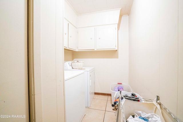 laundry room with crown molding, cabinets, light tile patterned floors, and washing machine and clothes dryer