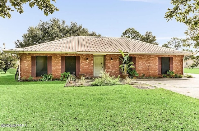 ranch-style house featuring brick siding, metal roof, and a front lawn