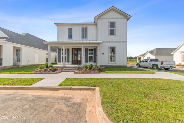 modern farmhouse with a front yard and covered porch