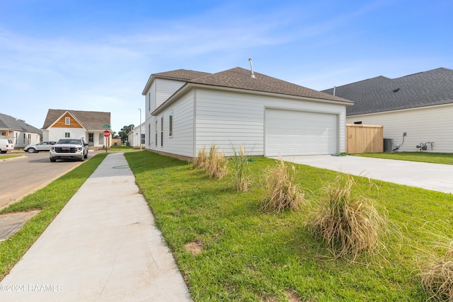 view of side of home with a garage, central AC, driveway, roof with shingles, and a lawn