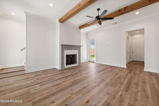 unfurnished living room featuring light wood-type flooring, a fireplace, visible vents, and beam ceiling