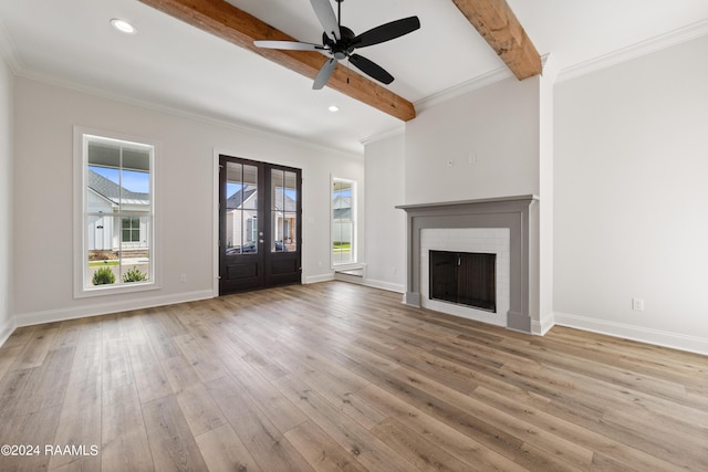 unfurnished living room featuring crown molding, baseboards, beamed ceiling, and wood finished floors