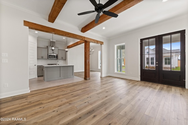 unfurnished living room featuring baseboards, french doors, light wood-type flooring, beam ceiling, and crown molding