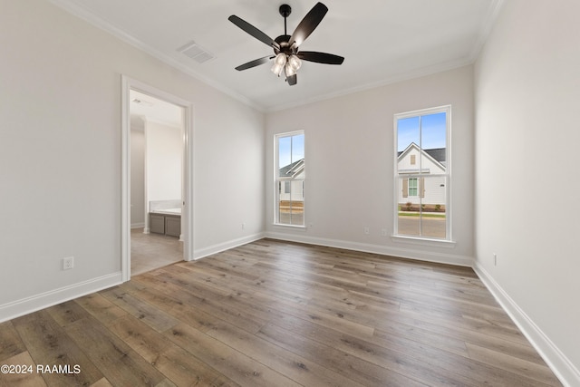 interior space featuring baseboards, wood finished floors, visible vents, and crown molding