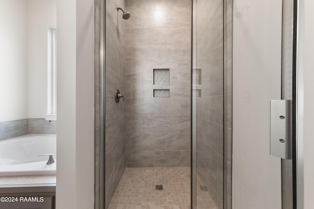 bathroom with a stall shower and a garden tub