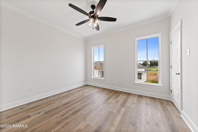 unfurnished room featuring light wood-style flooring, crown molding, baseboards, and a wealth of natural light