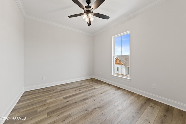 empty room featuring crown molding, baseboards, ceiling fan, and wood finished floors