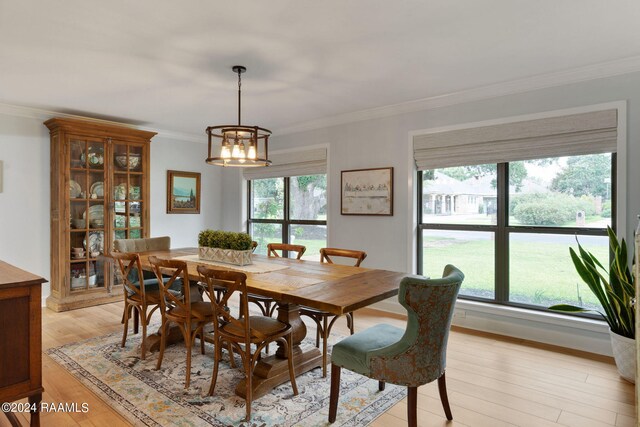 dining area featuring a chandelier, light hardwood / wood-style floors, and ornamental molding