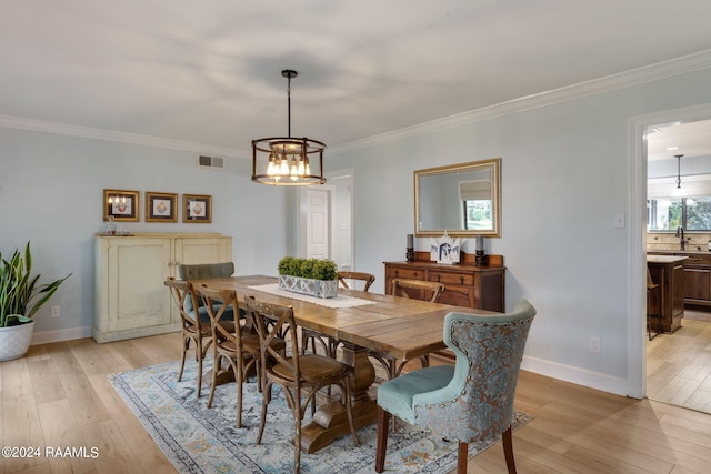 dining space featuring crown molding and light hardwood / wood-style flooring