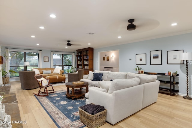 living room with light wood-type flooring, crown molding, and ceiling fan