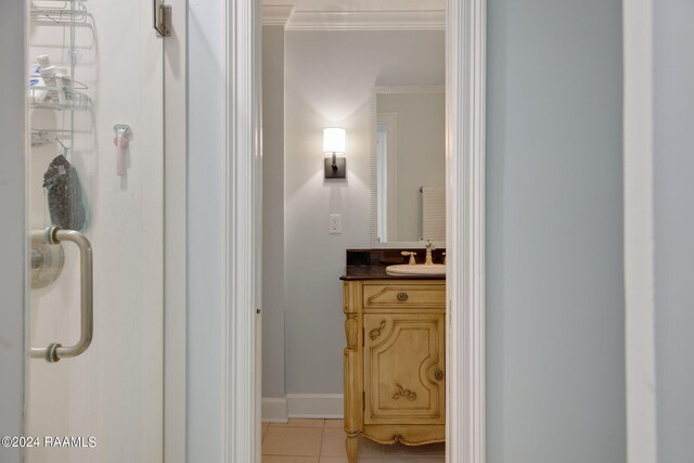 bathroom featuring tile patterned floors, ornamental molding, and vanity