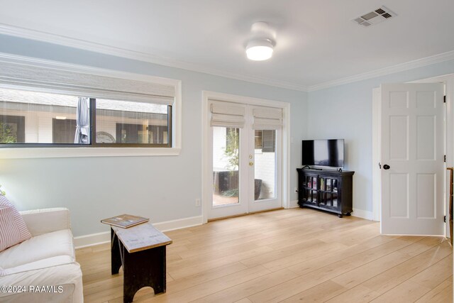 living room with crown molding, french doors, and light hardwood / wood-style floors