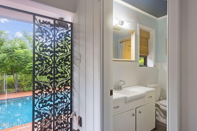 bathroom featuring tile walls, toilet, crown molding, and vanity