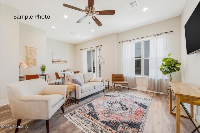 living room with hardwood / wood-style floors and ceiling fan