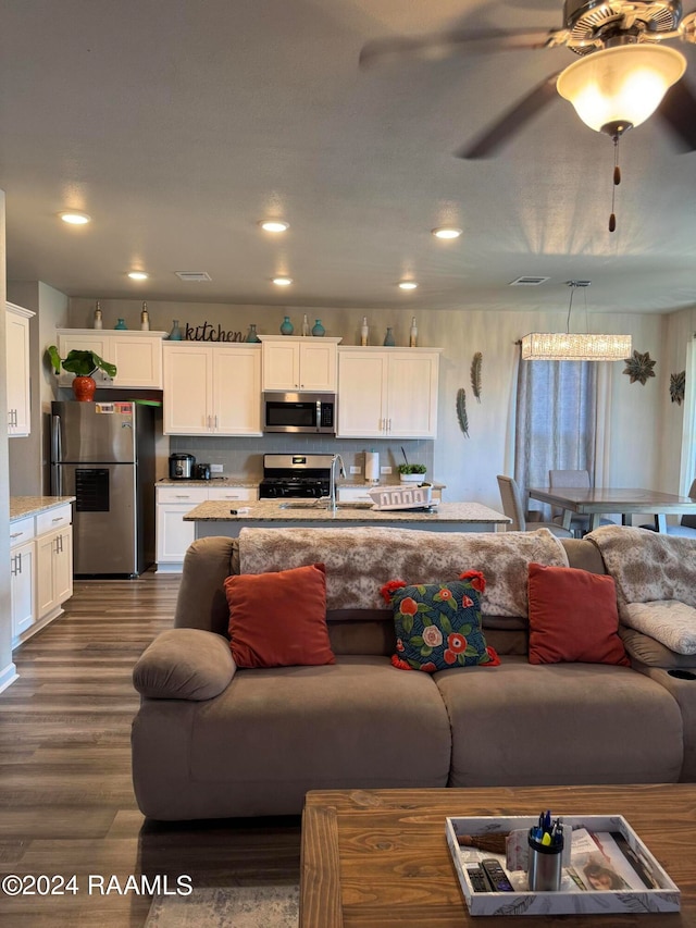 living room featuring ceiling fan, dark hardwood / wood-style floors, and sink