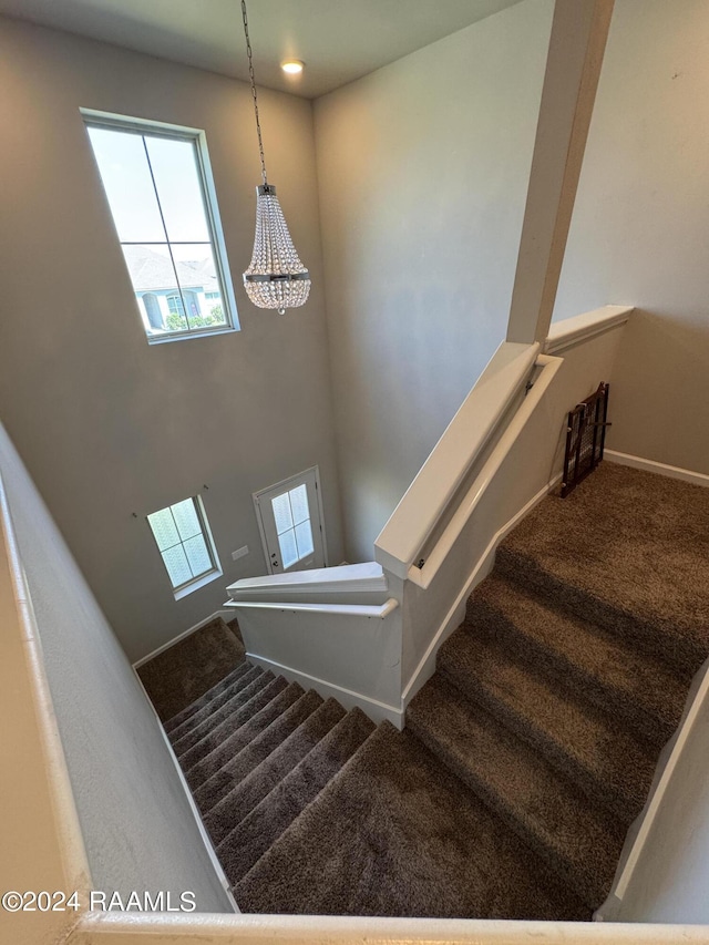 3134 Asbury Cir, Lake Charles, LA 70607 - stairway with an inviting chandelier, a healthy amount of sunlight, carpet flooring, and baseboards