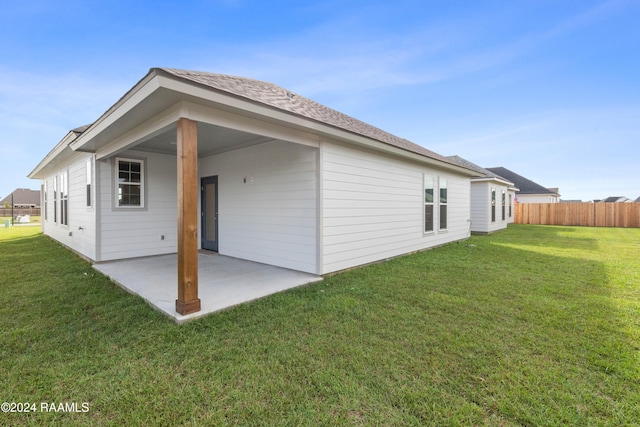 back of house with a lawn and a patio area