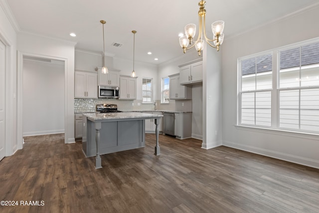 kitchen featuring hanging light fixtures, a breakfast bar area, dark hardwood / wood-style floors, a kitchen island, and appliances with stainless steel finishes