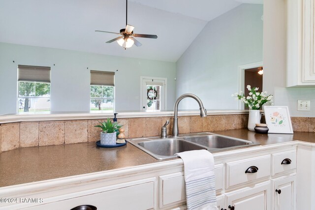 kitchen featuring vaulted ceiling, ceiling fan, sink, and white cabinets