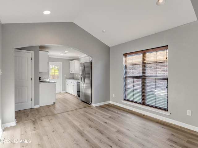 unfurnished living room with light wood-type flooring and vaulted ceiling