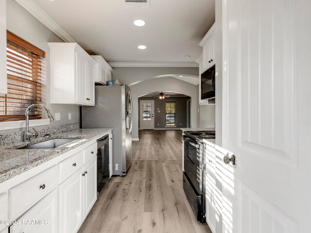 kitchen with black appliances, white cabinetry, a healthy amount of sunlight, and sink