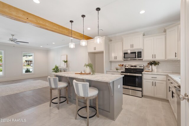 kitchen featuring stainless steel appliances, pendant lighting, light wood-type flooring, ceiling fan, and backsplash