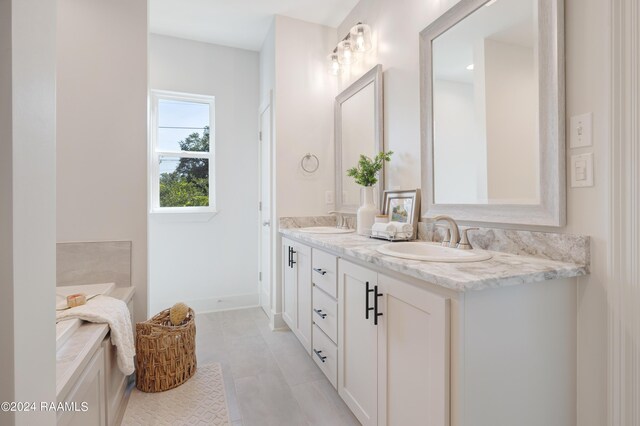 bathroom featuring double vanity, a bathing tub, and tile patterned flooring