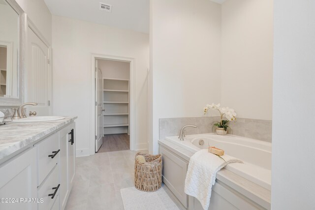 bathroom featuring vanity, a bathing tub, and tile patterned flooring