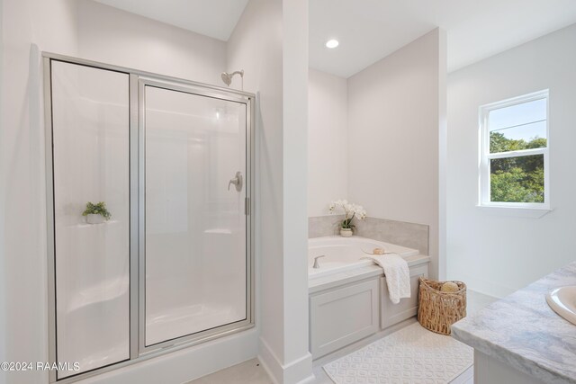 bathroom featuring vanity, plus walk in shower, and tile patterned flooring