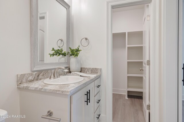 bathroom with vanity, toilet, and hardwood / wood-style flooring