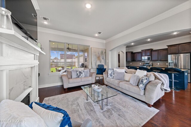 living room featuring a fireplace, dark hardwood / wood-style flooring, and ornamental molding